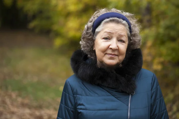 Grauhaarige ältere Frau in einem Herbstpark — Stockfoto