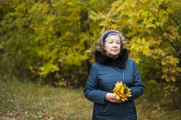 Gray haired elderly woman in an autumn park — Stock Photo, Image