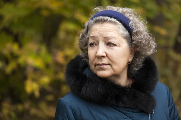 灰色头发的老年妇女，在秋天的公园 — 图库照片