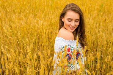 Altın buğday alan arka plan üzerinde genç kadın