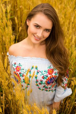 Altın buğday alan arka plan üzerinde genç kadın