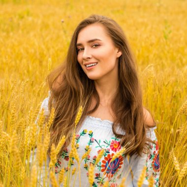 Altın buğday alan arka plan üzerinde genç kadın