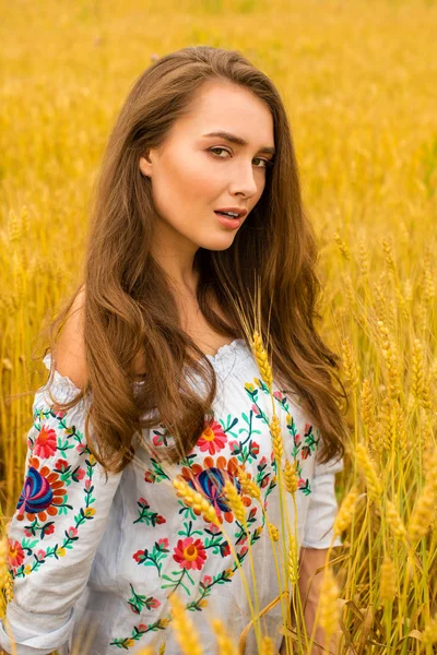 Молода жінка на фоні поля золотої пшениці — стокове фото