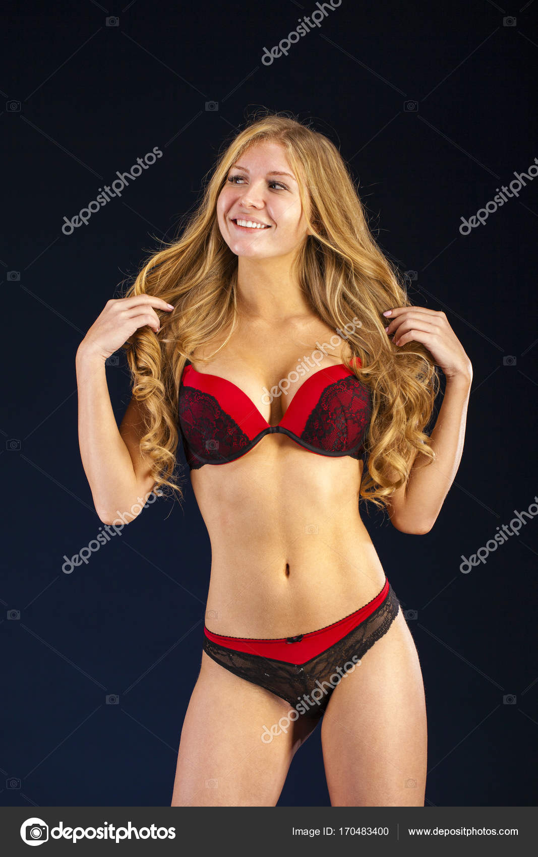 Sexy Brunette Woman Wearing Red Bra Posing Near White Wall Stock