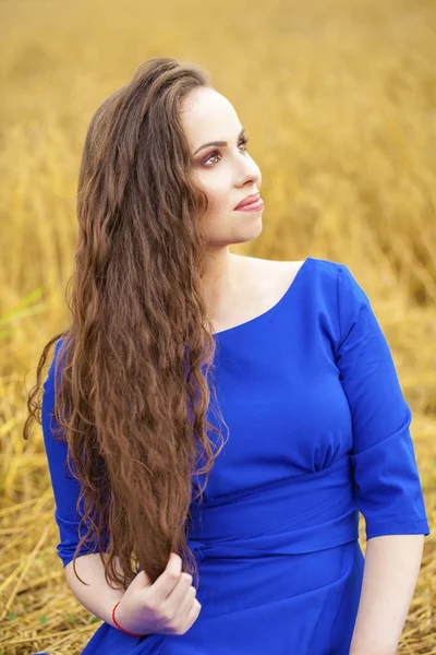 Retrato de una joven sobre un fondo de campo de trigo dorado — Foto de Stock