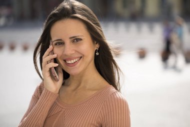 Güzel genç esmer kadın telefon ederken