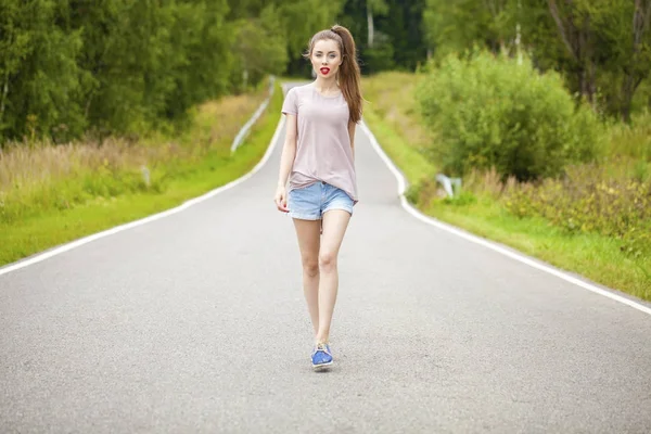 Jeune belle femme aux cheveux bruns en jeans bleu — Photo