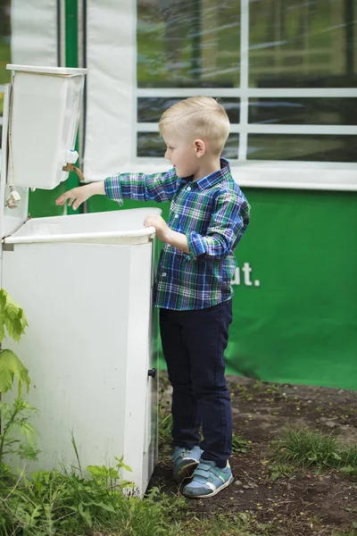 Blond liten pojke tvätta handen i handfat — Stockfoto