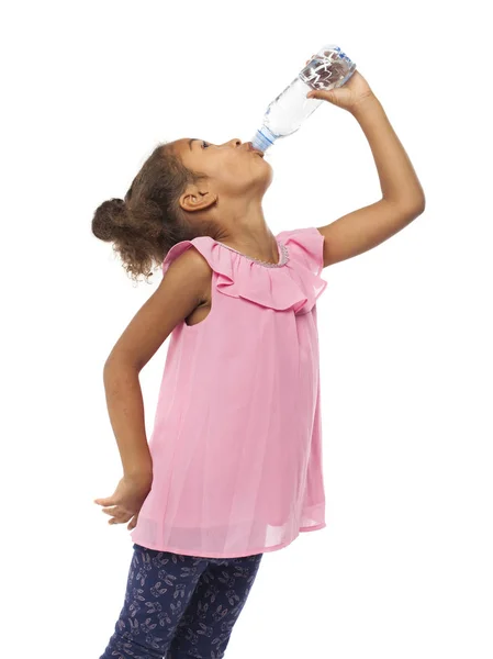 Маленькая африканская мулатка пьет воду из бутылки. — стоковое фото
