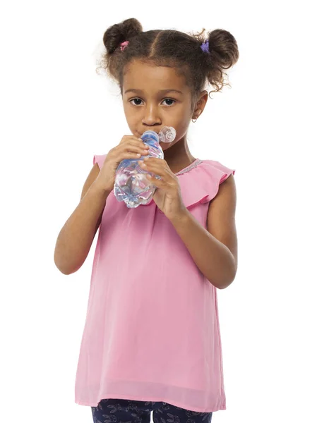 Pequena menina africana mulata bebe água de uma garrafa — Fotografia de Stock