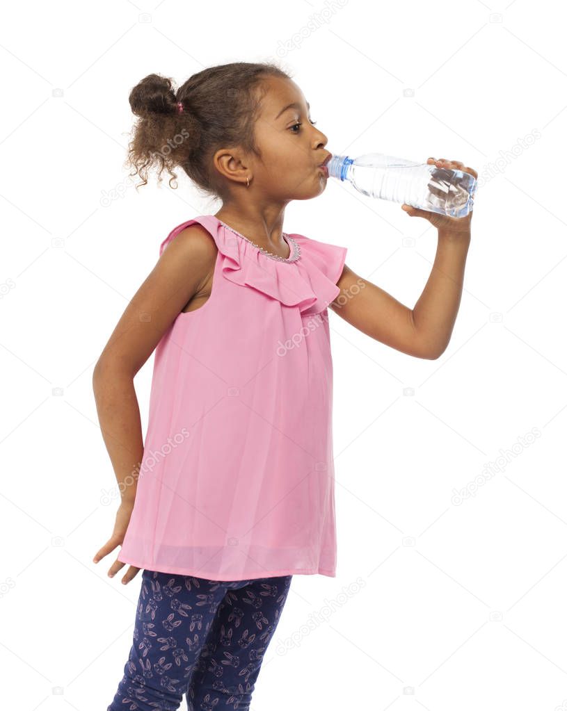 Little mulatto african girl drinks water from a bottle