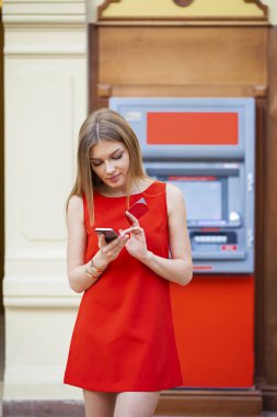 Arka planda alışveriş merkezi Atm üzerinde sarışın kadın