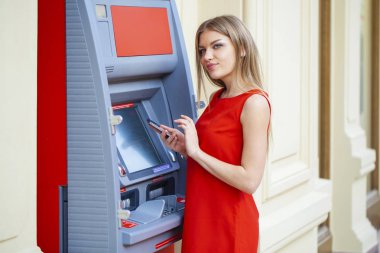 Arka planda alışveriş merkezi Atm üzerinde sarışın kadın