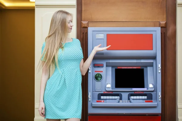 Молодая блондинка вставляет кредитку в банкомат — стоковое фото