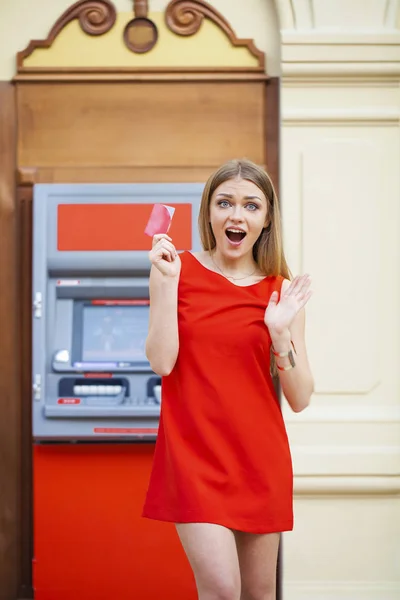 Heureuse femme blonde retirant de l'argent de la carte de crédit au distributeur automatique — Photo