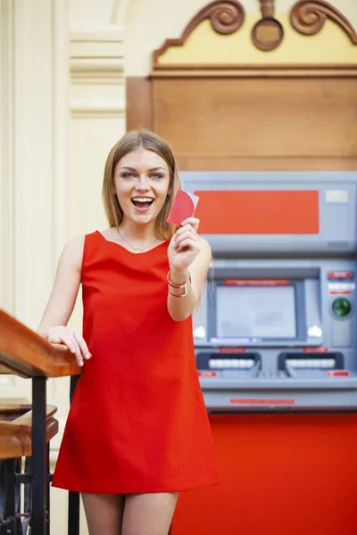 Ευτυχισμένος ξανθιά γυναίκα ανάληψη χρημάτων από την πιστωτική κάρτα σε ΑΤΜ — Φωτογραφία Αρχείου