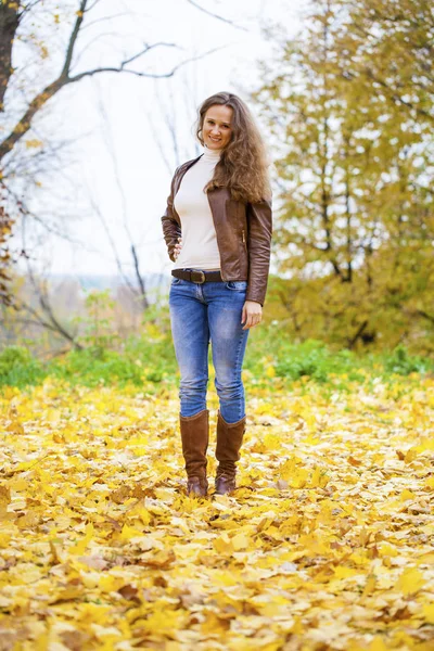 Autumn fashion image of young woman walking in the park — Stock Photo, Image