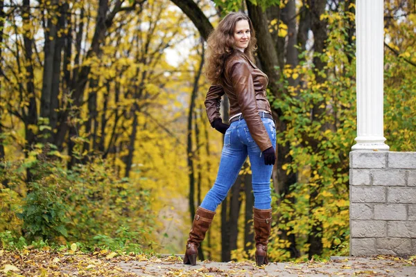 Autumn fashion image of young woman walking in the park — Stock Photo, Image