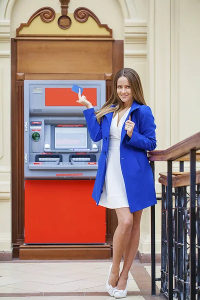 Jonge vrouw invoegen van een credit card naar Atm — Stockfoto