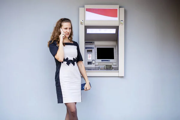 Young woman inserting a credit card to ATM — Stock Photo, Image