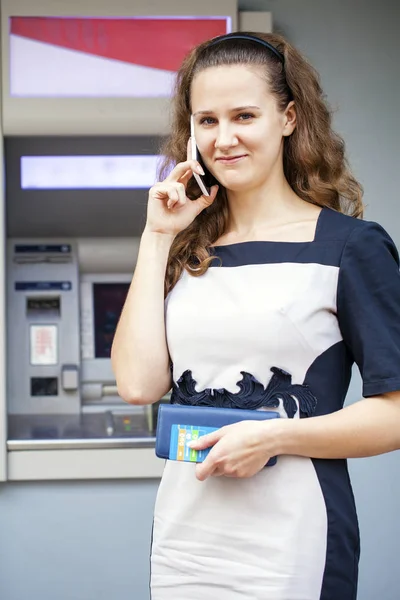 Молода жінка вставляє кредитну картку в банкомат — стокове фото