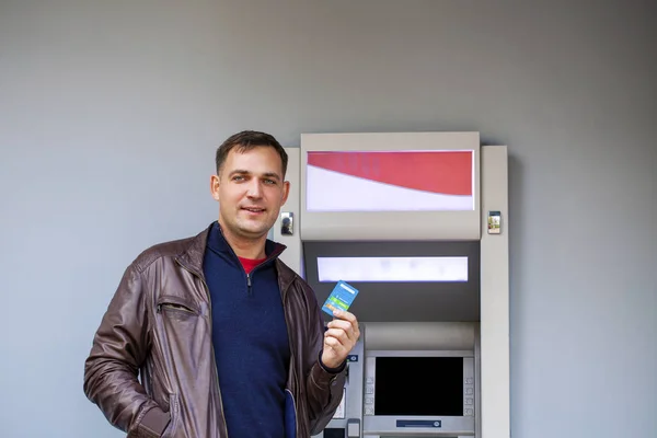 Young man inserting a credit card to ATM — Stock Photo, Image