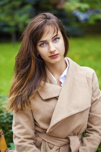 Ritratto di una giovane bella donna in cappotto beige — Foto Stock