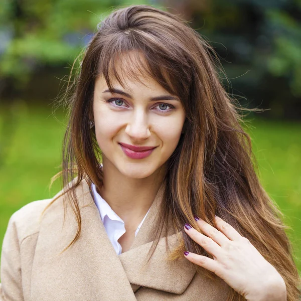 Porträt einer jungen schönen Frau im beigen Mantel — Stockfoto