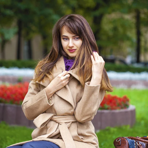 Portret van een jonge mooie vrouw in beige jas — Stockfoto