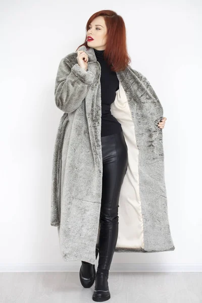 Joven hermosa mujer de pelo rojo en abrigo de piel gris hecha de artificios —  Fotos de Stock
