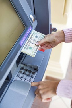 Genç sarışın kadın bir nakit dolar tutuyor