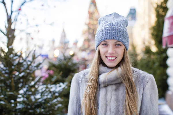 Portret van een jonge vrouw in een blauwe gebreide muts en de grijze nerts co — Stockfoto