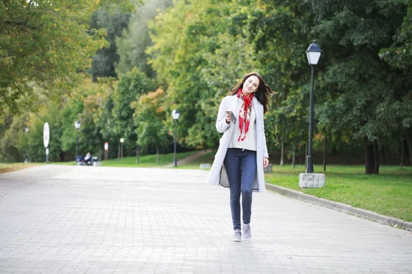 Portrait of happy young brunette woman in gray coat talking on t — Stock Photo, Image