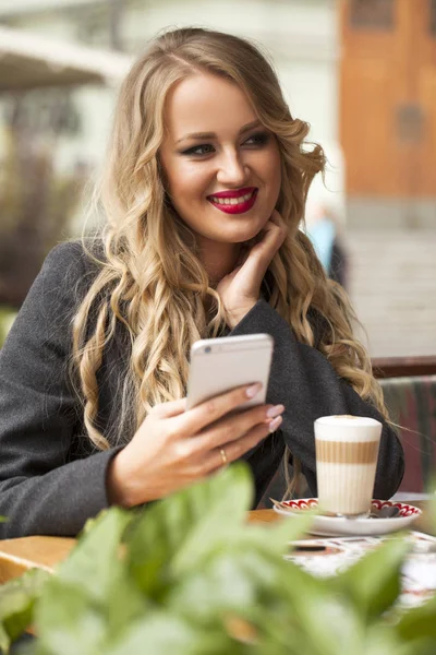 Молодая женщина пьет коктейль в кафе — стоковое фото