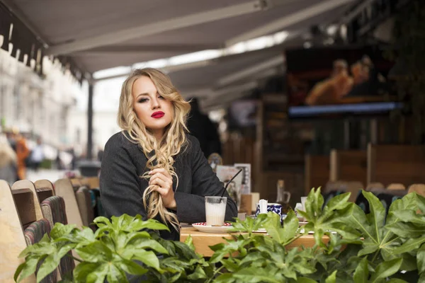 Молода жінка п'є коктейль в кафе — стокове фото