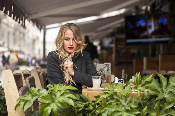 Ung kvinna dricka cocktail i ett café — Stockfoto