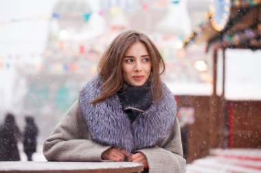 Bir kürk yakalı gri paltolu genç esmer kadın 