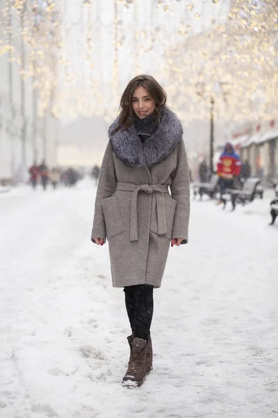 Young brunette woman in a gray coat with a fur collar — Stock Photo, Image