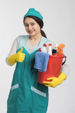 Temizlik araçları ve ürünleri sepete tutan genç kadın