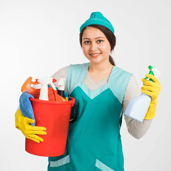 Mujer joven sosteniendo herramientas de limpieza y productos en cubo — Foto de Stock