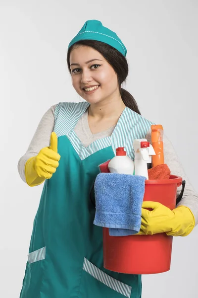 Junge Frau hält Putzwerkzeug und Produkte im Eimer — Stockfoto