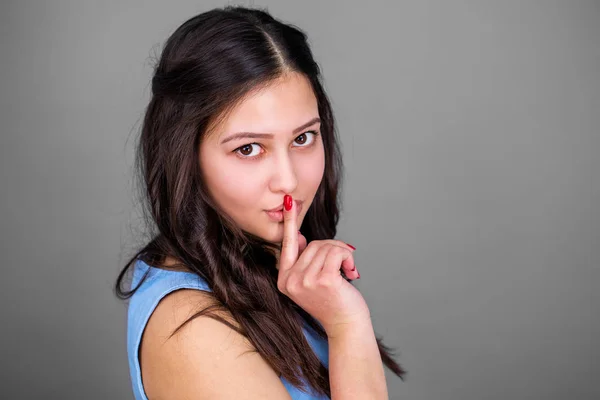 Jovem mulher bonita colocou o dedo indicador nos lábios como sinal de sile — Fotografia de Stock