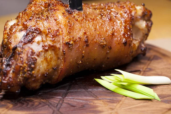 Restaurant dish - large baked pork knuckle on a wooden tray — Stock Photo, Image