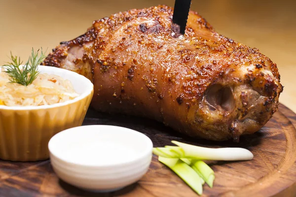 Restaurant dish - large baked pork knuckle on a wooden tray — Stock Photo, Image