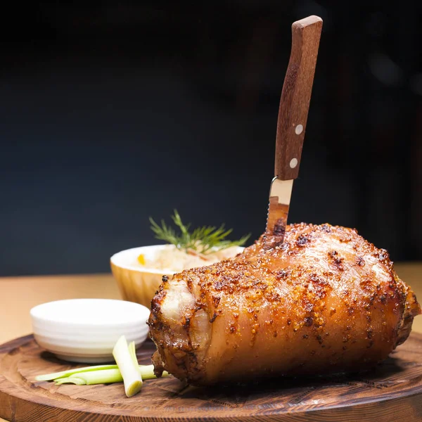 Restaurantgericht - große gebackene Schweinshaxe auf einem Holzblech — Stockfoto