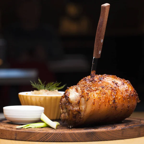 Piatto di ristorante - grande nocca di maiale al forno su un vassoio di legno — Foto Stock