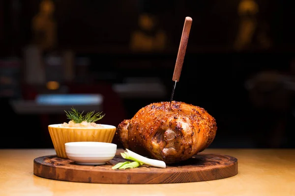 Restaurantgericht - große gebackene Schweinshaxe auf einem Holzblech — Stockfoto