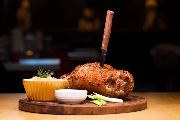 Piatto di ristorante - grande nocca di maiale al forno su un vassoio di legno — Foto Stock