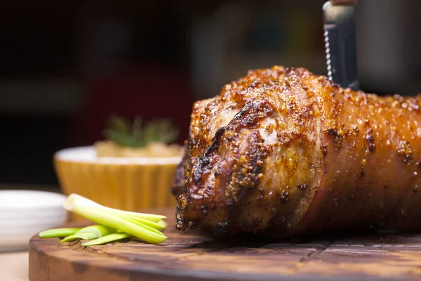 Restaurant dish - large baked pork knuckle on a wooden tray — Stock Photo, Image