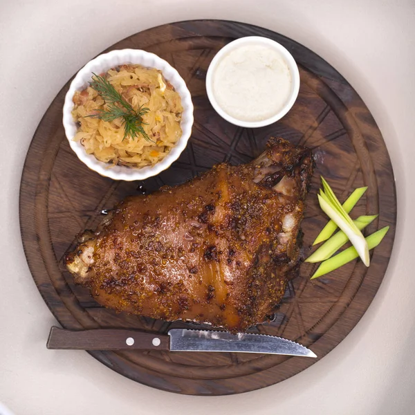 Piatto di ristorante - grande nocca di maiale al forno su un vassoio di legno — Foto Stock